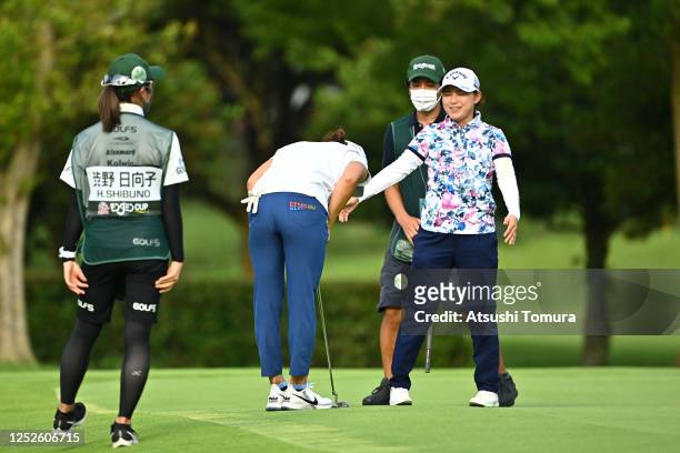 Hinako Shibuno of Japan bows to Sakura Yokomine of Japan after holing out on the 9th green during the second round of the Earth Mondamin Cup at the...