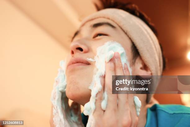 zelf beauty spa voor jonge man - facial cleanser stockfoto's en -beelden