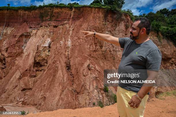 Mayor Joao Carlos Teixeira da Silva points out an erosion in Buriticupu, Maranhao state, Brazil, on April 21, 2023. - An unusual phenomenon caused by...