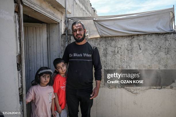 Syrian refugee Adil Sheho and his children pose at their house in the southwest of the city centre of Sanliurfa on April 28, 2023. - Since the...