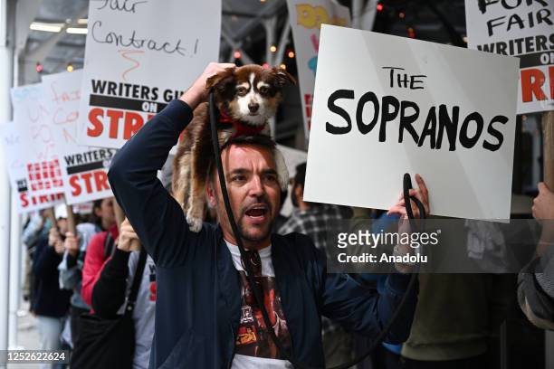 Members of the Writers Guild of America East hold signs as they walk for the second day on the picket-line outside of Netflix's New York office on...