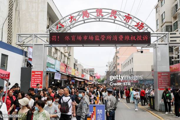 This photo taken on May 2, 2023 shows people visiting a market with barbecue restaurants during the 5-day Labour Day holiday in Zibo, in China's...