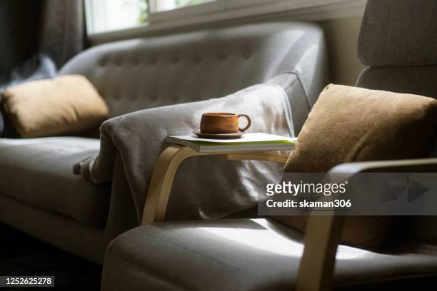 close up wooden coffee cup on cozy sofa bed - comodità foto e immagini stock