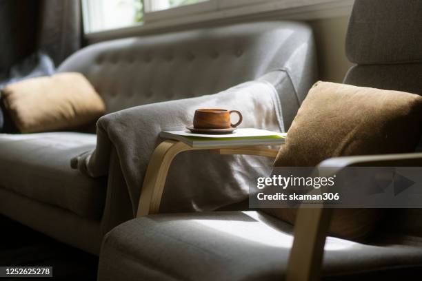 close up wooden coffee cup on cozy sofa bed - period cup stockfoto's en -beelden