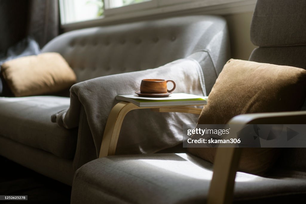 Close up Wooden coffee cup on cozy sofa bed