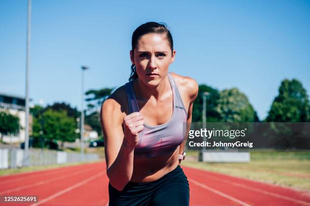 action portrait of 30 year old female runner on sports track - year in focus sport stock pictures, royalty-free photos & images