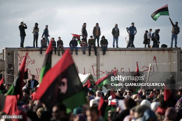 Libyan protesters wave their old national flag during an anti-regime rally in the eastern city of Benghazi on March 9, 2011 as rebel fighters broken...