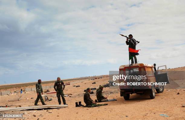 Libyan rebel fighters pray before engaging in clashes with forces loyal to leader Moamer Kadhafi, just few kilometers outside the oil town of Ras...