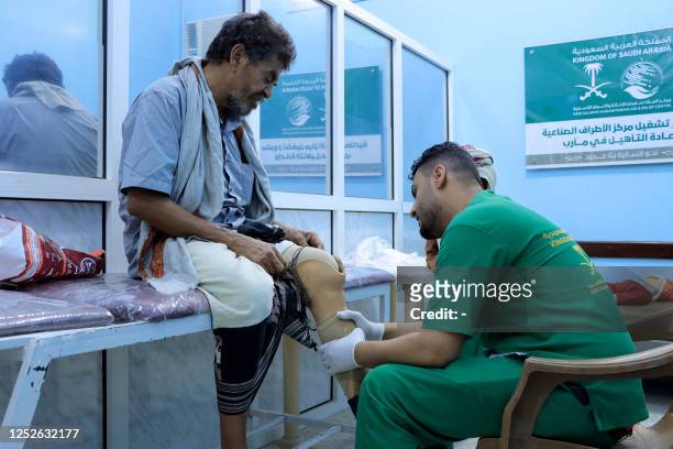 Picture taken on May 3 shows a lab technician speaking with a patient at the prosthetic limb clinic in the King Salman Humanitarian Aid & Relief...