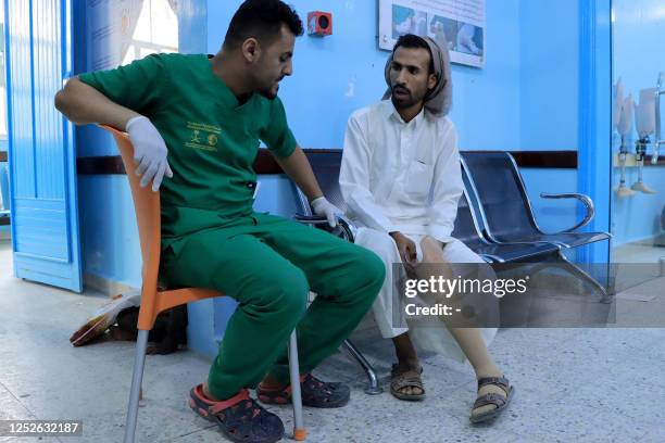 Picture taken on May 3 shows a lab technician speaking with a patient at the prosthetic limb clinic in the King Salman Humanitarian Aid & Relief...