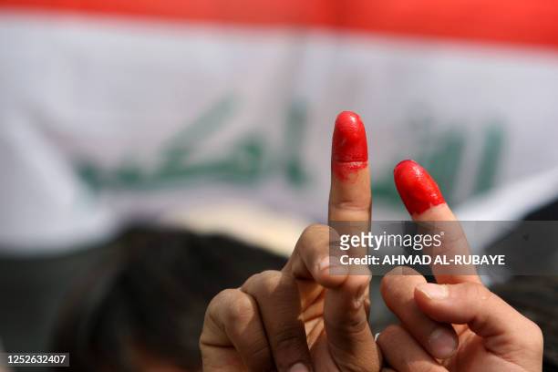 Iraqi demonstrators shout anti-government slogans and point their ink-stained index fingers in refrence to someone who had voted, during a protest in...