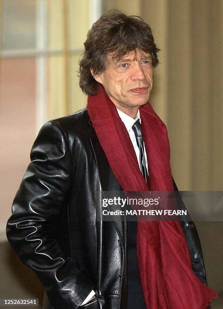 Lead singer for the Rolling Stones, Mick Jagger, arrives at Buckingham Palace, London, 12 December to receive his knighthood. Jagger will kneel...