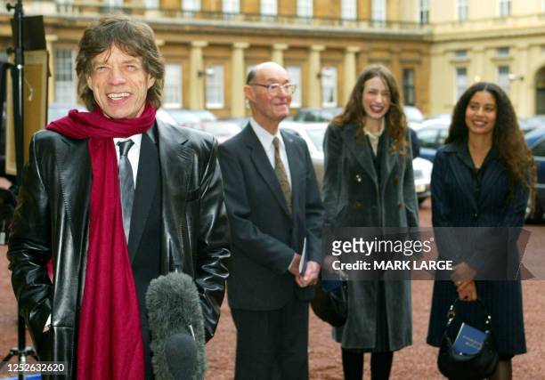 Lead singer of British group the Rolling Stone Sir Mick Jagger speaks to reporters as his his 92-year-old father, Joe and daughters Elizabeth and...