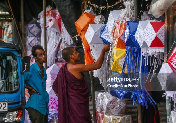 Buddhist monk wait to buy lanterns ahead of Vesak festival on May 4, 2023 in Colombo. Vesak, also known as Buddha Jayanti, Buddha Purnima, Buddha...