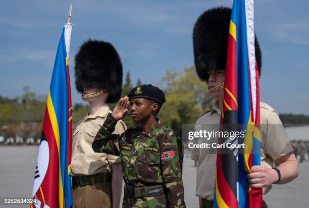 Soldier from Eswatini salutes as she poses for a photograph with British Guardsmen after a military parade for representatives of the Commonwealth...