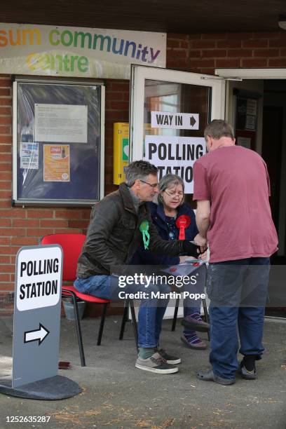 Green and Labour Party tellers take a voter's number outside the polling station as voting opens in the local election on May 4, 2023 in Norwich,...