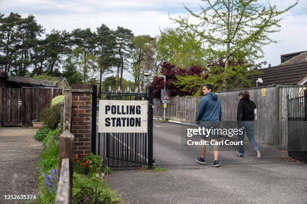 People walk to a polling station to cast their vote in the local elections on May 4, 2023 in Brookwood, United Kingdom.