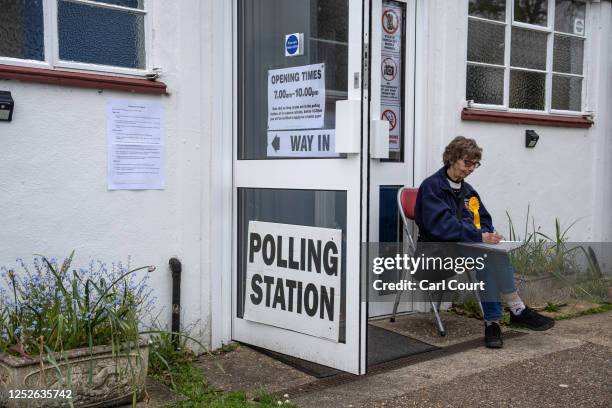 Liberal Democrat Party teller sits outside a polling station during the local elections on May 4, 2023 in Brookwood, United Kingdom.