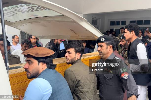 People carry a teacher's dead body into an ambulance from a hospital after a sectarian violence inside a school in Parachinar, in Kurram district on...