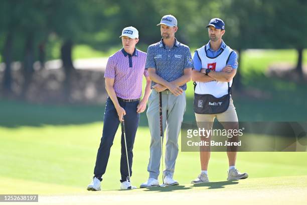 Mackenzie Hughes of Canada and Webb Simpson stand near the 15th green during the first round of the Wells Fargo Championship at Quail Hollow Club on...