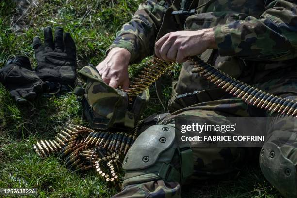 Swiss soldier handles an ammunition belt during a live shooting exercise in the military training area of Les Pradieres next to Les...