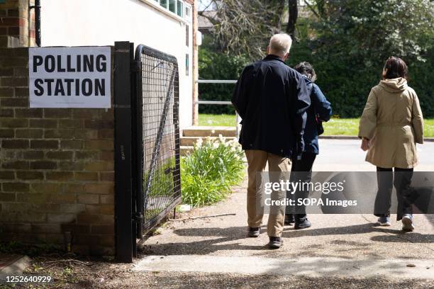 People walk towards a polling station in Egham, as members of the public go to cast their votes. Elections are being held in 230 of England's 317...