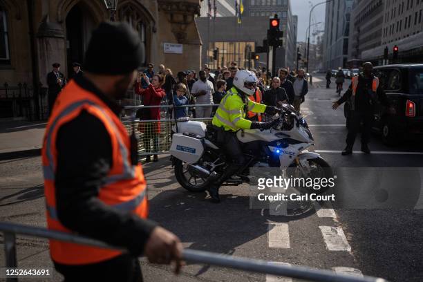 Police motorcycle escorts a vehicle through a security barricade near Westminster Abbey on May 04, 2023 in London, England. The Coronation of King...