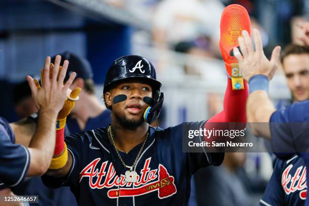Ronald Acuna Jr. #13 of the Atlanta Braves celebrates with teammates after scoring against the Miami Marlins during the first inning at loanDepot...