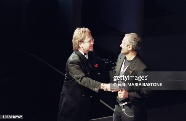 British singer Elton John presents Italian designer Gianni Versace with the 1992 Council of Fashion Designers of America International Award at the...