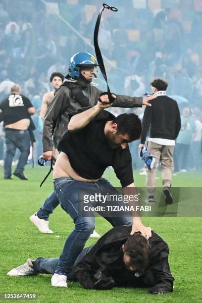 Fan of Udinese attacks a fan of Napoli as spectators invade the pitch at the end of the Italian Serie A football match between Udinese and Napoli on...