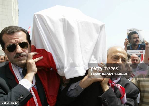 Newly elected Lebanese Parliament Member Gebran Tueini and MP Akram Shehayeb carry the coffin of murdered columnist Samir Kassir who regularly wrote...