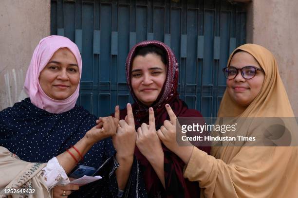 Woman muslim voters show inked fingers, exiting the booth after casting their vote during the local bodies election at the picture gallery polling...
