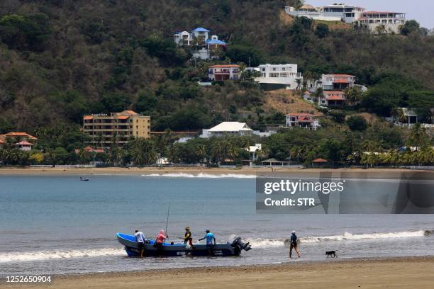 Tourists board a boat in the Pacific coastal town of San Juan del Sur, Nicaragua, on April 25, 2023. - Drawn to the natural beauty, security and...