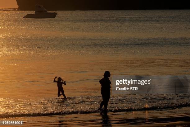 Tourists bathe in the Pacific coastal town of San Juan del Sur, Nicaragua, on April 25, 2023. - Drawn to the natural beauty, security and...