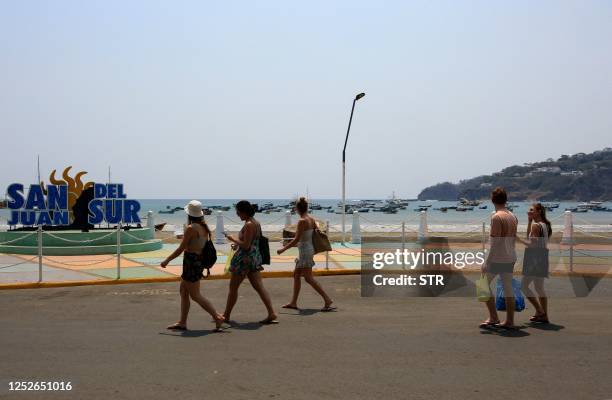 Tourists walk in the Pacific coastal town of San Juan del Sur, Nicaragua, on April 25, 2023. - Drawn to the natural beauty, security and tranquility,...