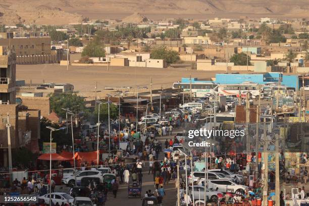 People gather in the Sudanese town of Wadi Halfa bordering Egypt on May 4, 2023. - In three weeks of fighting between rival Sudanese generals that...
