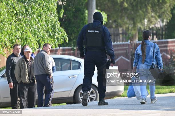 Masked policeman secures an area in the village of Dubona near the town of Mladenovac, about 60 kilometres south of Serbia's capital Belgrade, on May...