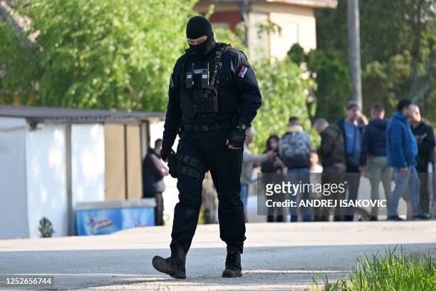Masked policeman secures an area in the village of Dubona near the town of Mladenovac, about 60 kilometres south of Serbia's capital Belgrade, on May...