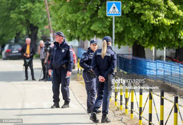 Police officers stand guard near a crime scene in the village Dubona, near Mladenovac on May 5, 2023 in Dubona, Serbia. A gunman identified by...