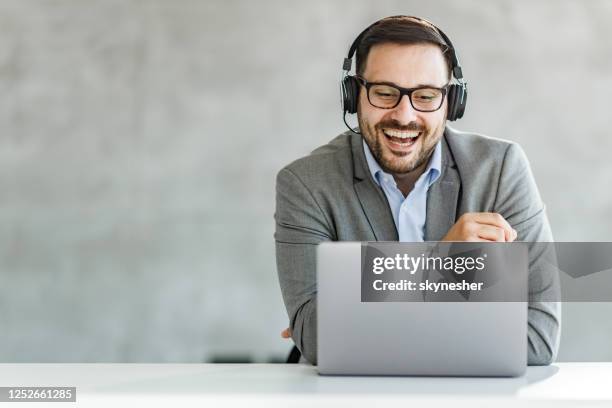 happy businessman having a video call over laptop in the office. - business headphones stock pictures, royalty-free photos & images