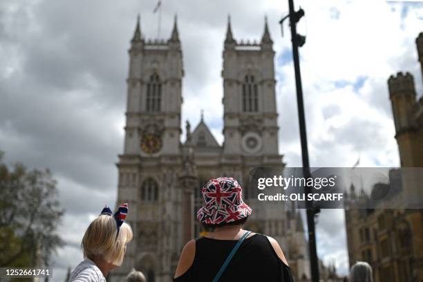 Members of the public wearing Union flag hats and bows are seen outside Westminster Abbey in central London, on May 5 ahead of the coronation weekend.