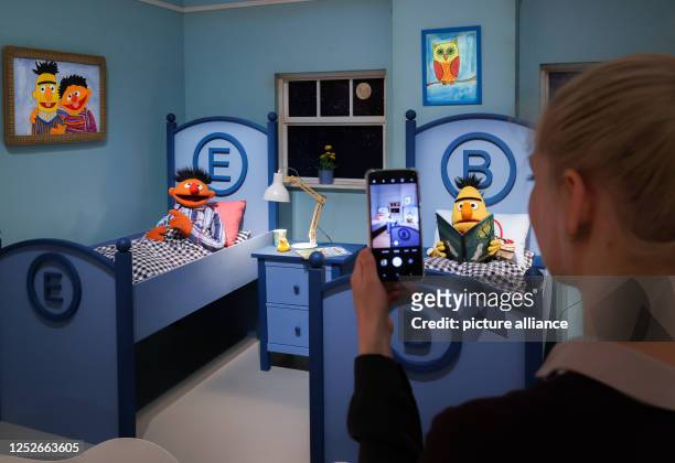 Visitor to the exhibition "Sesame Street. 50 Years Who, How, What!" photographs the characters "Ernie" and "Bert" on display at the Museum für Kunst...
