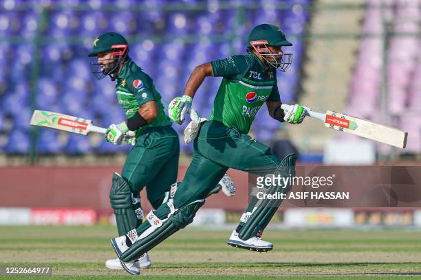 Pakistan's Babar Azam and Mohammad Rizwan run between the wickets during the fourth one-day international cricket match between Pakistan and New...