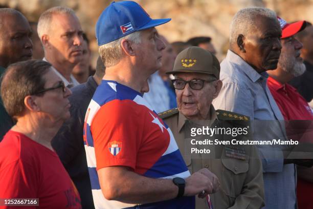 Former president Raul Castro speaks with an aide as he stands next to Cuba's president Miguel Diaz Canel during the May Day celebrations, on May 5,...