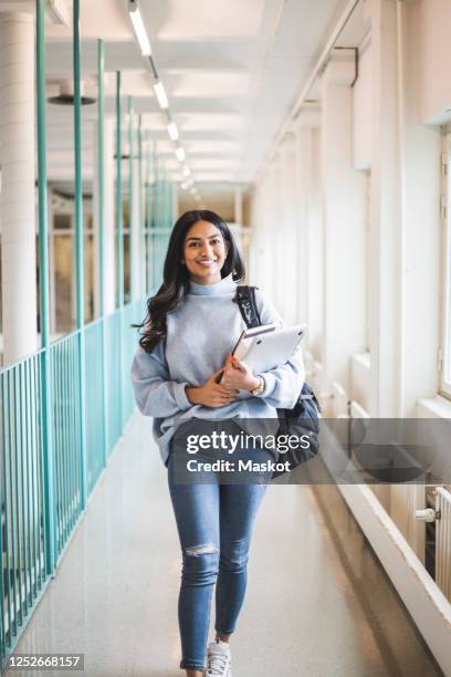 portrait of young female student walking in corridor of university - indian college students stock-fotos und bilder