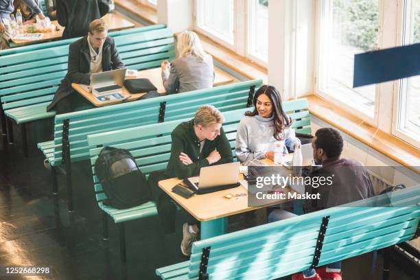 high angle view of male and female students sitting in cafeteria at university - college canteen bildbanksfoton och bilder