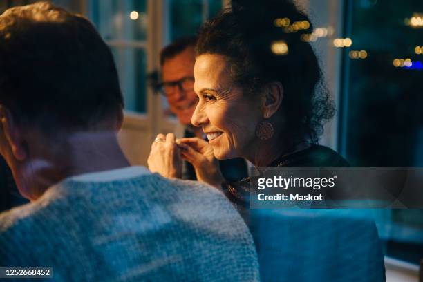 smiling senior woman looking at man during dinner party - evening meal stock-fotos und bilder
