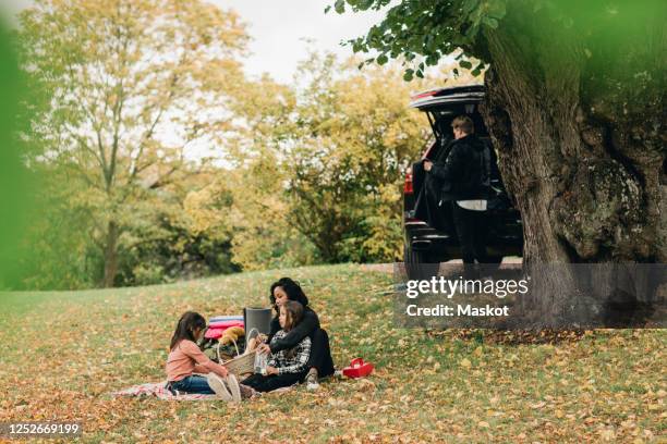 parents with daughters enjoying picnic during autumn - car picnic stock pictures, royalty-free photos & images