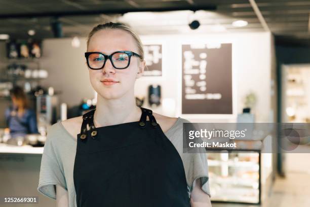 portrait of confident transgender owner standing in coffee shop - gender fluid fotografías e imágenes de stock