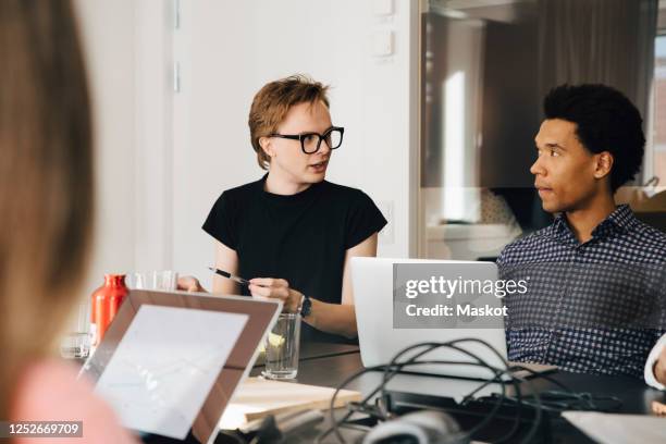 businessman looking young genderblend professional during discussion in board room - gender bender 個照片及圖片檔